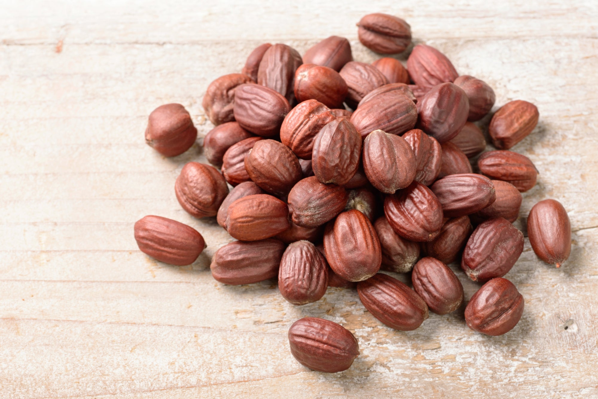 Jojoba seeds on plank, used to make jojoba liquid wax, jojoba oil